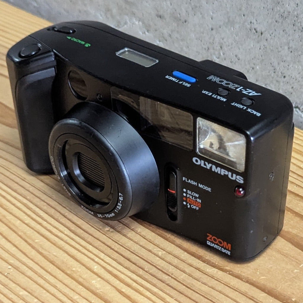 Olympus AZ-1 Zoom QuartzDate 35mm camera isometric front view on stand