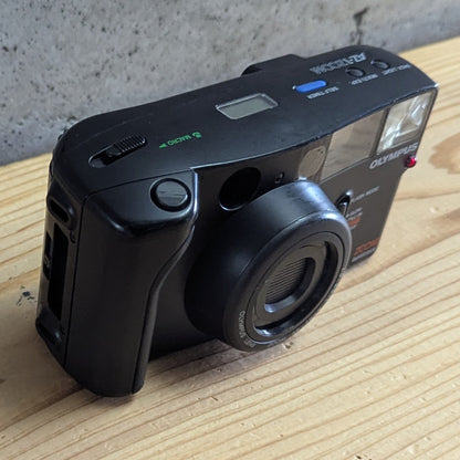 Olympus AZ-1 Zoom top and side grip view showing thumb zoom wheel and macro switch