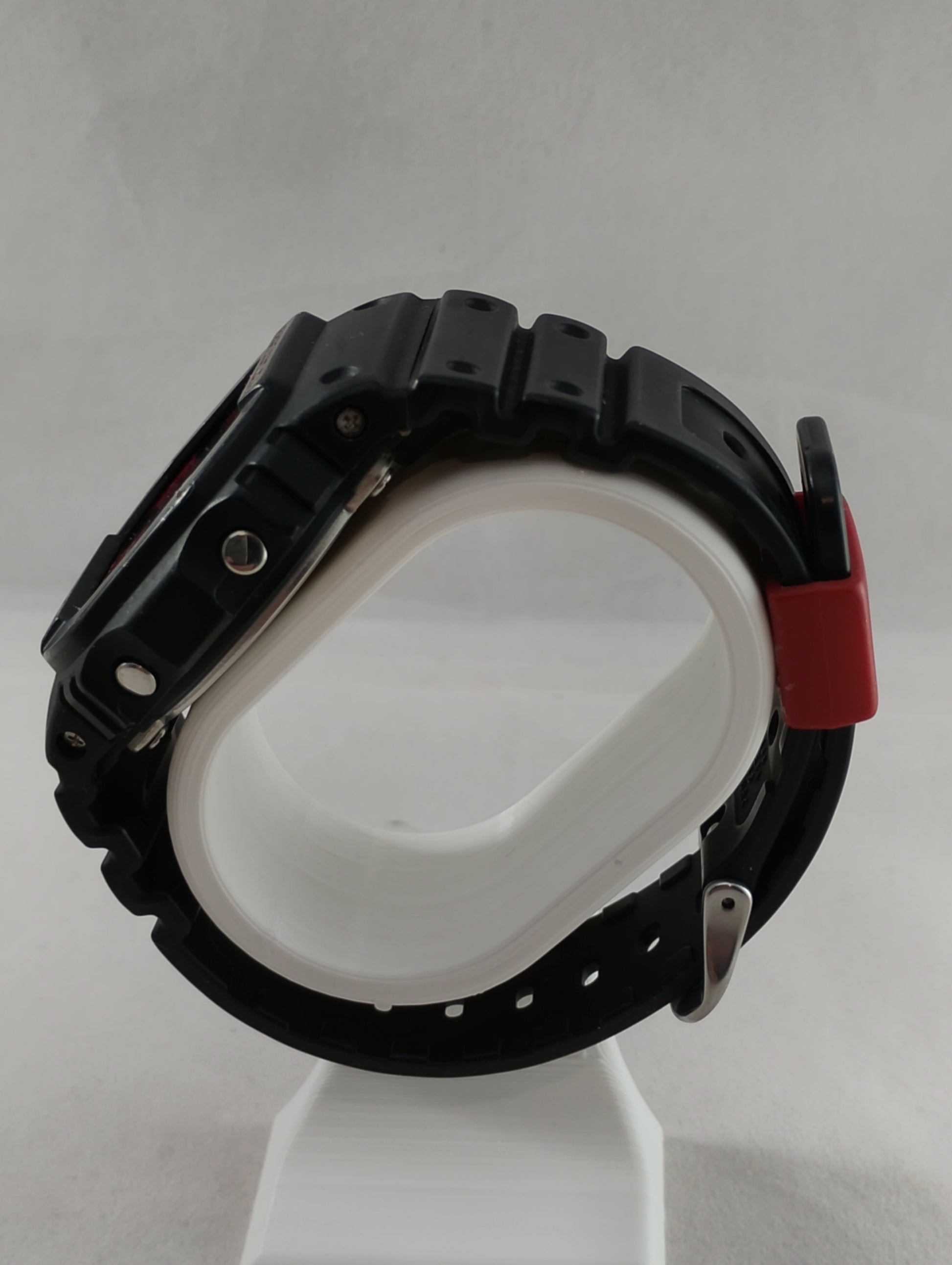 Side profile of G-Shock DW-5600JK-1 showing adjustment buttons and case thickness