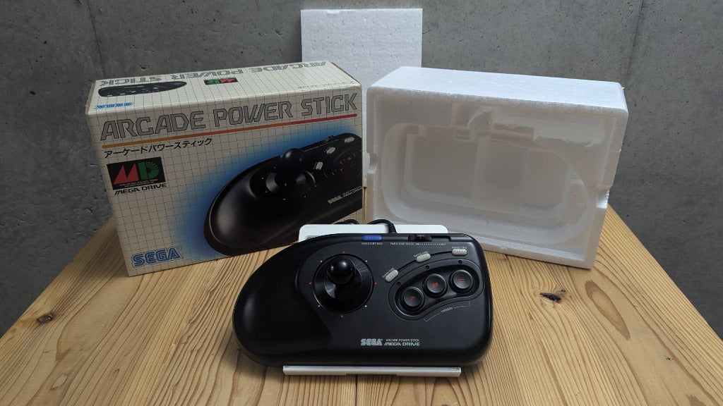 Angled front perspective of Sega Arcade Power Stick controller with Japanese retail box